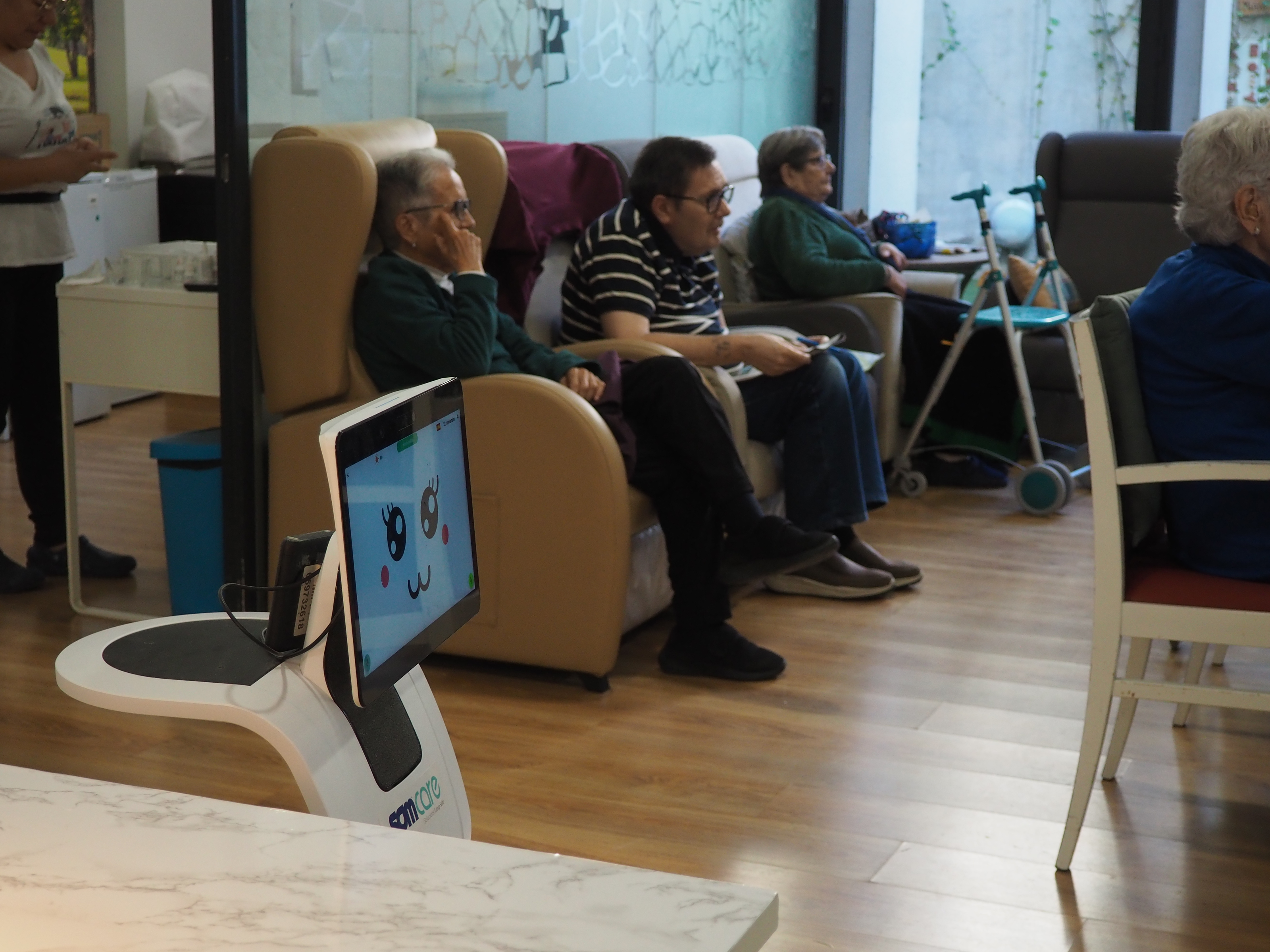 Robot assitencial a una sala de la residència acompanyant a persones grans