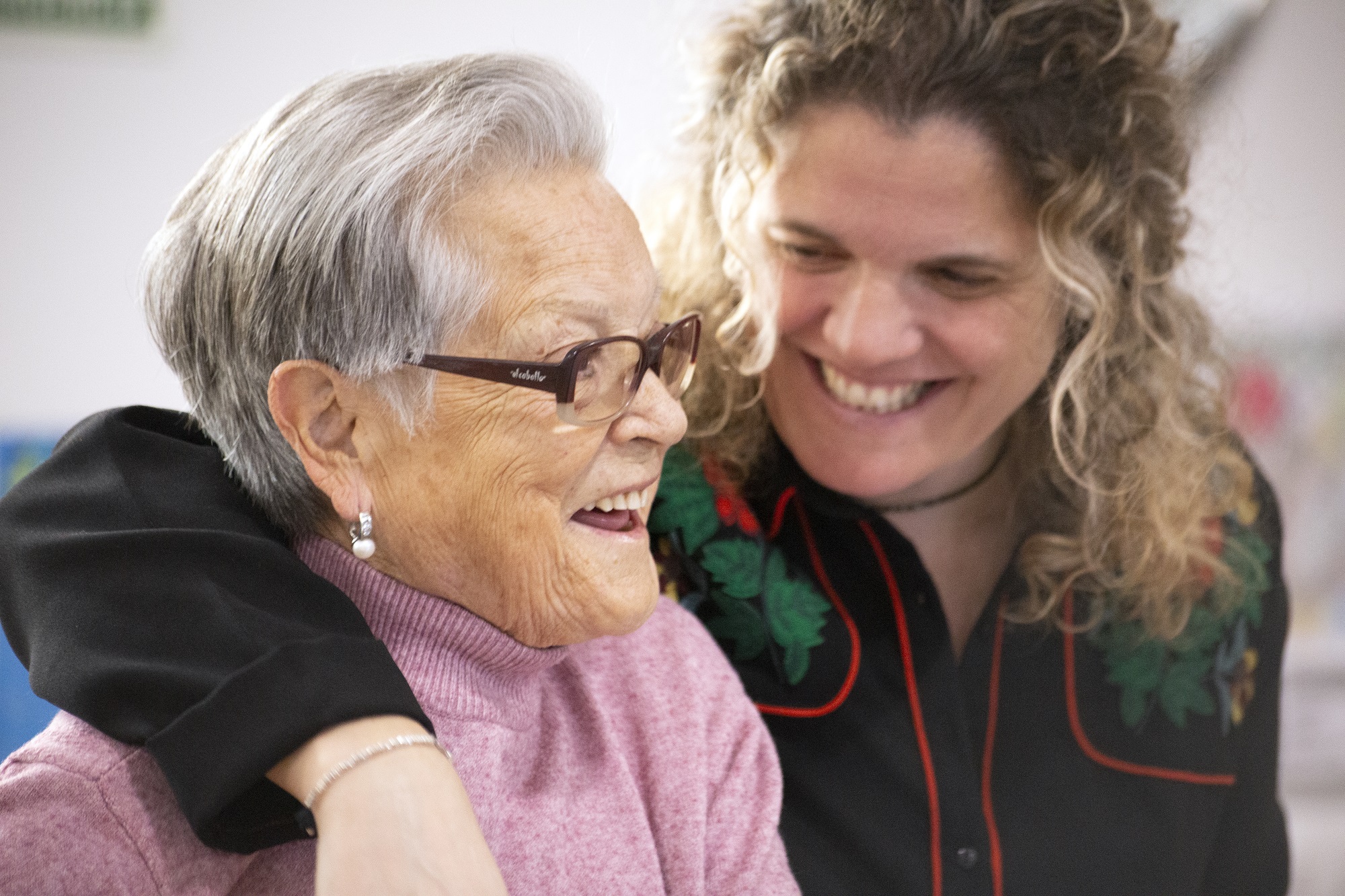 Treballadora acompanyant a persona gran a dins de la residència