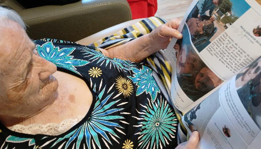 Persona gran llegint la revista Famileo a la residència Colònia Güell