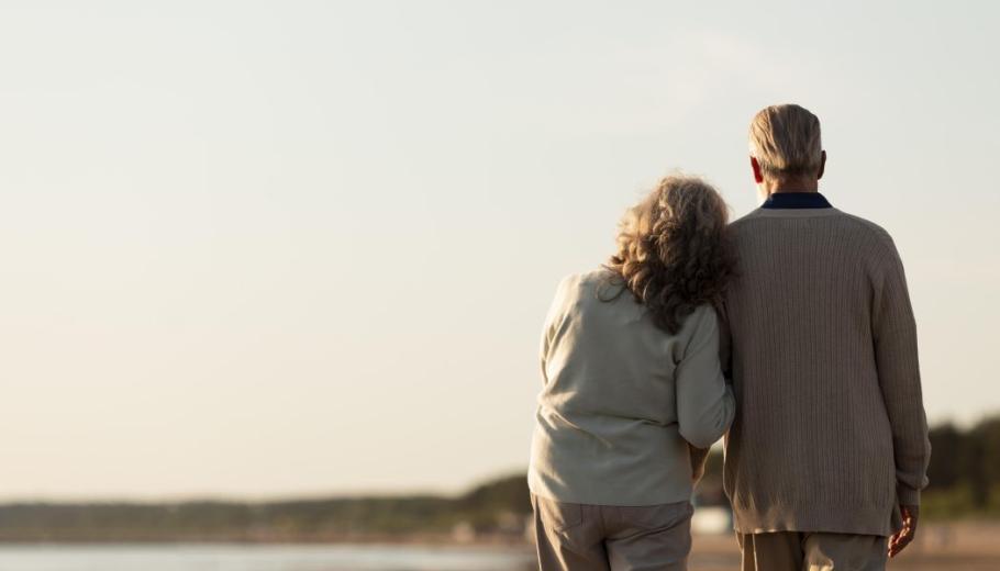 Parella de persones grans passejant per la platja