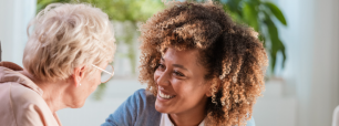Treballadora social mirant somrient a una persona gran