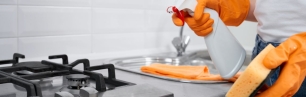 Una persona netejant amb guants i spray una cuina