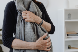 Persona gran agafant-se el cos amb les mans