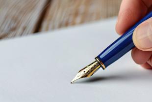 Mano con una pluma escribiendo