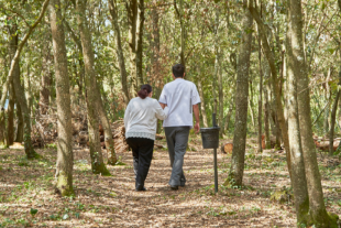 Cuidador i persona gran passejant pel bosc