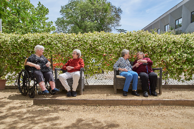 persones grans al jardí de la residència Colònia Güell