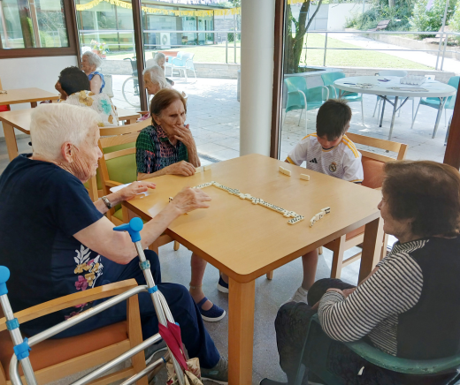 personas mayores y niños jugando a dominó